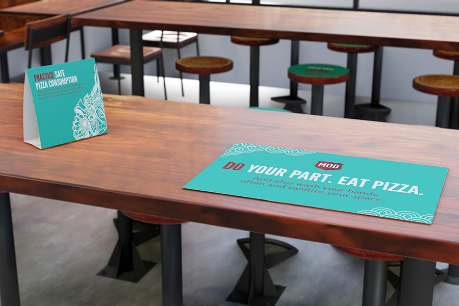 Tables at a MOD location feature bright teal miniature tents and placemats.