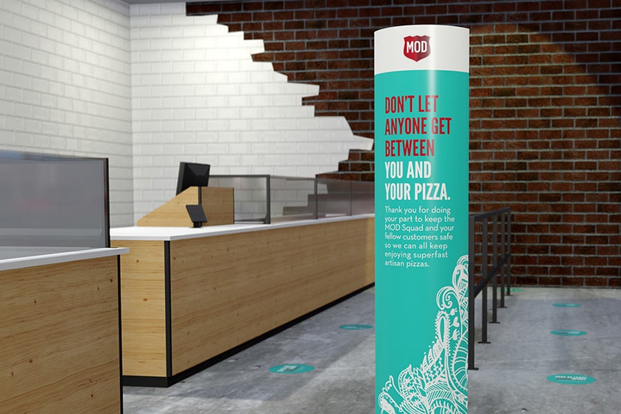 In a 3D-rendered MOD pizzeria, a tall column sign tells visitors “Don't let anyone get between you and your pizza.”